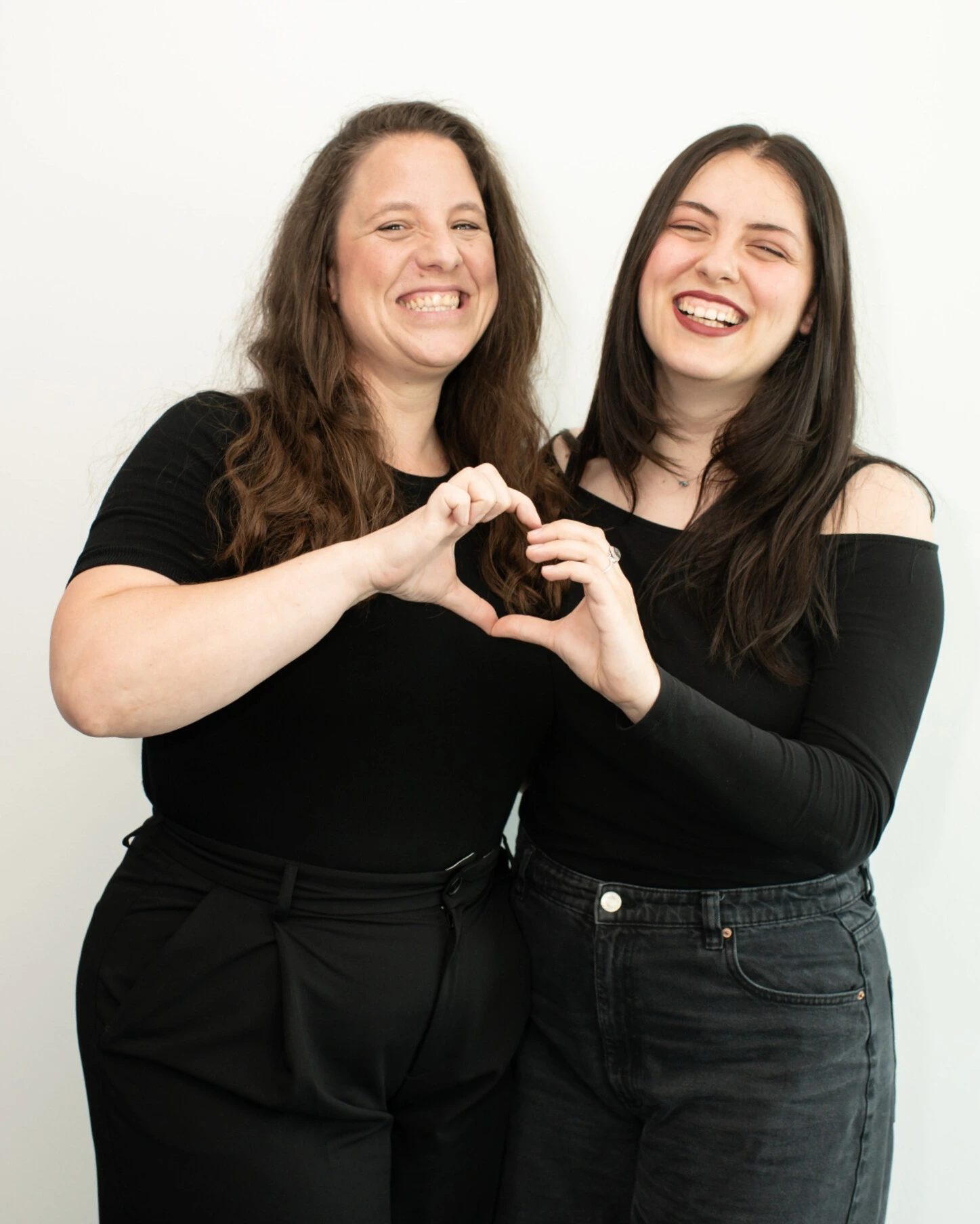 Two ClickTerm colleagues making a heart shape with their hands